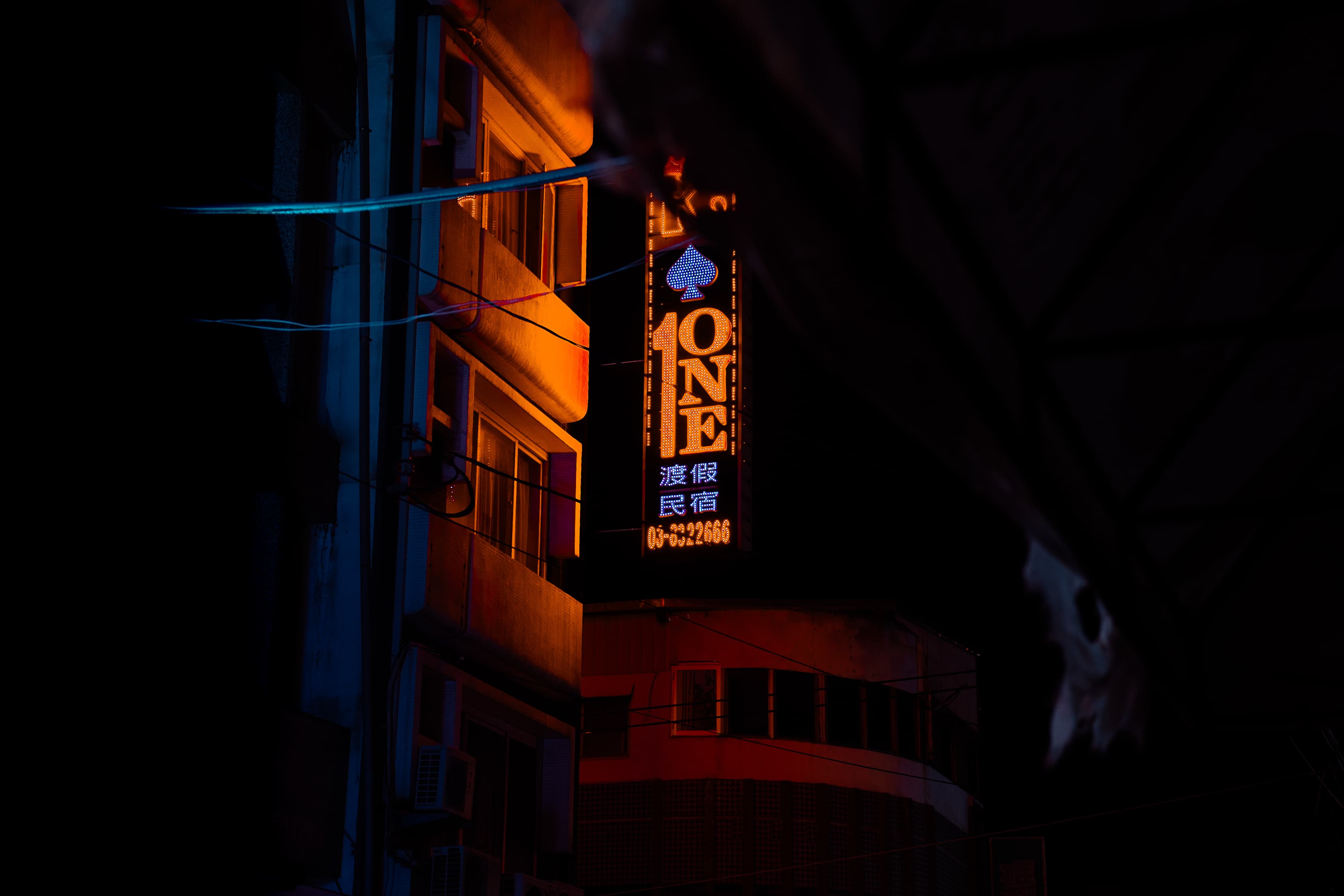 Neon guesthouse sign glowing at night